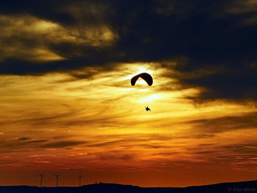 Paraglider am Horizont bei Dämmerung